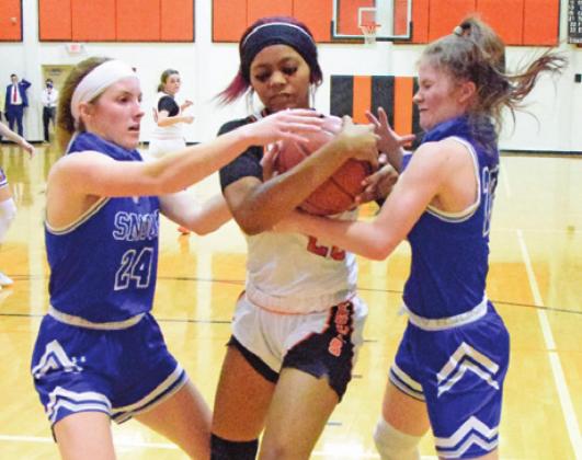 SOMERVILLE’S XADRIA MARTIN fights with Snook’s Jaycie Brisco and Kamree Walker for possession of the ball during the Snook-Somerville district game last Tuesday. -- Tribune photo by Denise Squier