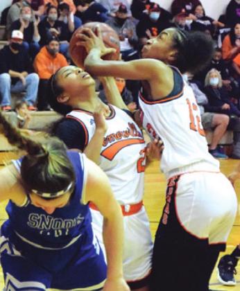 SOMERVILLE’S JAZMINE Jackson gets hit while Ra’Maya Carter prepares to shoot the ball during the Snook-Somerville game last Tuesday. Also pictured is Snook’s Avery Kovar. -- Tribune photo by Denise Squier