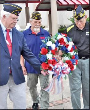 LAYING THE WREATH at the Veterans Memorial are Donny Wood of the American Legion post, Henry Probst of the VFW post and Bill Moore of the DAV post.