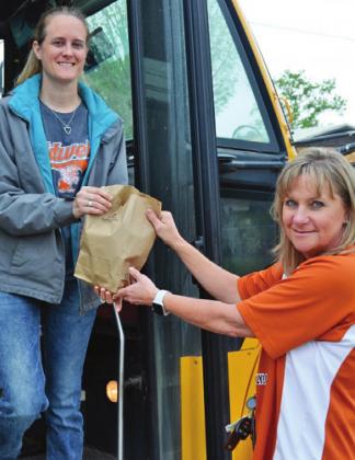 AMY GILL AND JENNIFER Dollery helped on Monday, March 30, at the Caldwell ISD food distribution bus on Freeman Street. The district is providing the food even though school is closed for now due to the COVID-19 situation. -- Tribune photo by Roy Sanders