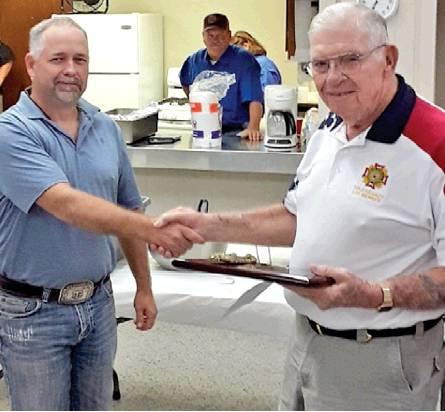 GARNETT GERDES IS presented this plaque of appreciation by Burleson County Judge Keith Schroeder. Gerdes was recognized for years of devotion to the Deanville Volunteer Fire Department.