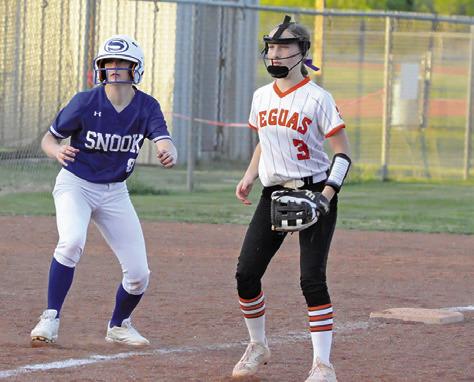 SNOOK’S KYLIE PRICE and Somerville’s Aubrey Flencher watch the batter at home plate during the Snook-Somerville game last Tuesday night in Somerville. -- Tribune photo by Denise Squier