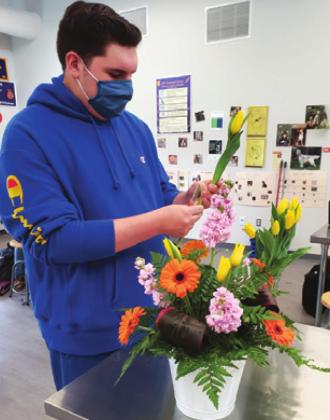 CALDWELL FFA’S Julian Rodriguez prepares his floral design for the Texas Tablescape competition. His theme was spring.