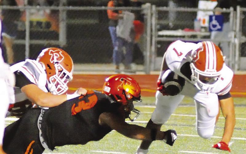 CALDWELL’S E.J. ROGERS tries to keep his balance while running the ball against Smithville. -- Tribune photo by Denise Squier