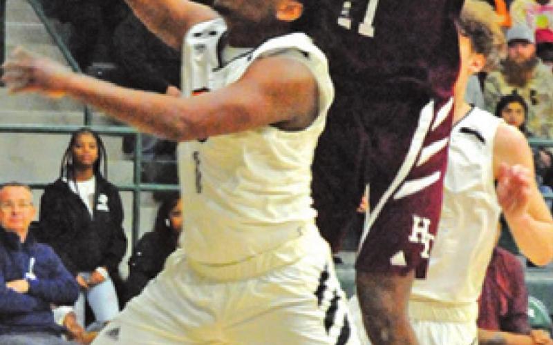 ARVIS BURNS ATTEMPTS to get a shot off while Hearne’s Jabari Dunn defends during last Friday’s area playoff game at Rudder High School. -- Tribune photo by Denise Squier