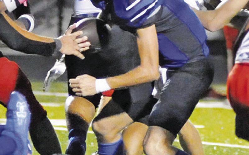 SNOOK QUARTERBACK Brett Withem runs for yardage against the Burton defense. Tribune photo by Denise Squier