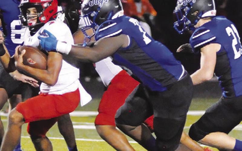 THE SNOOK DEFENSE, including Robert Carter and Michael Eaton move in for this tackle against Burton. Tribune photo by Denise Squier