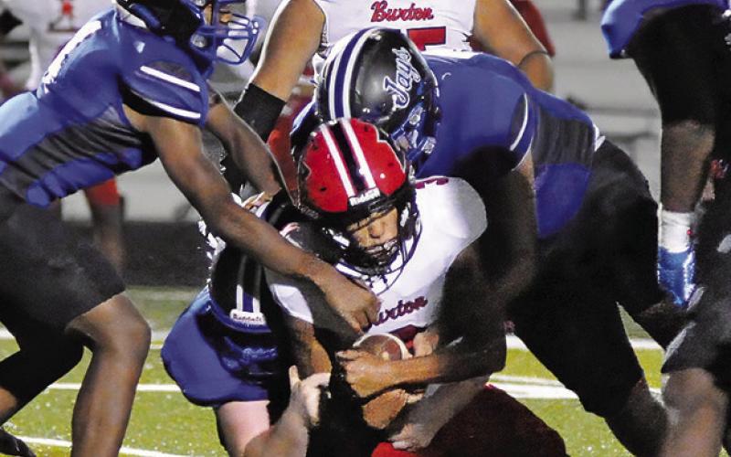 SNOOK’S DEFENSE TACKLES a Burton ball carrier. Pictured are John Carr, Alex Bond and Ramiro Martinez. Tribune photo by Denise Squier
