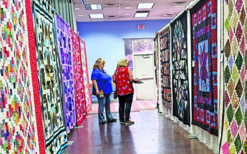 MANY VISITORS TO THE CREATIVE Memories Quilt Guild Quilt Show took time to vote for their favorite creations. Tribune photo by Denise Squier