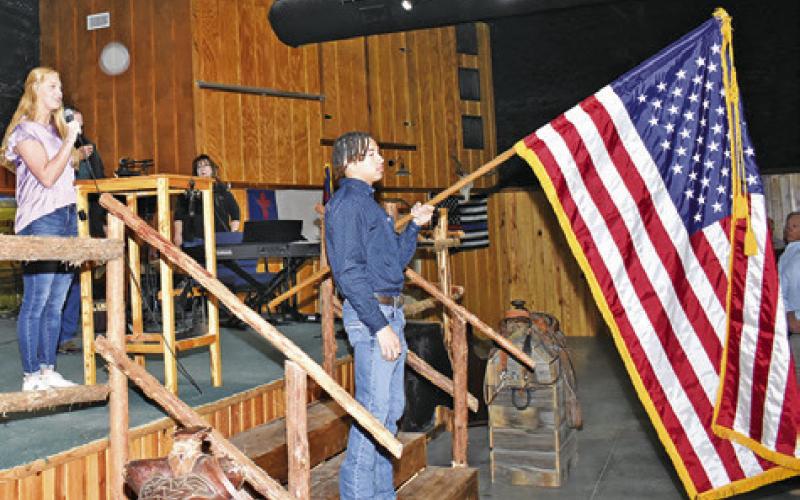 CAITLYN FAUST, LEFT, and Kyle Brooks, holding the American Flag, participate on Tuesday at the annual Burleson County Ag Breakfast.