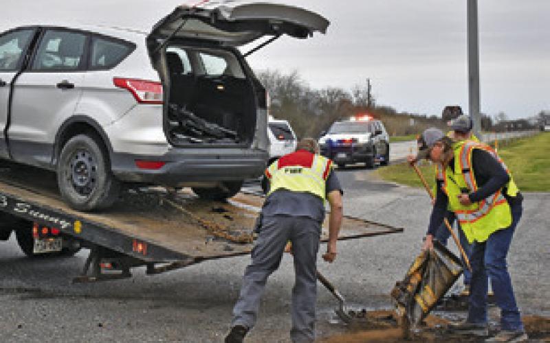 FIREFIGHTERS WORK THE scene of this accident on Feb. 27 at the State Highway 21 East and F.M. 50 intersection. Tribune photo by Roy Sanders
