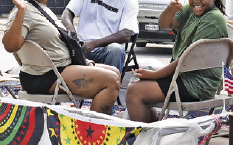 VETERANS RODRICK Canady and Pamela Jones wave to the crowd at the Juneteenth Parade.