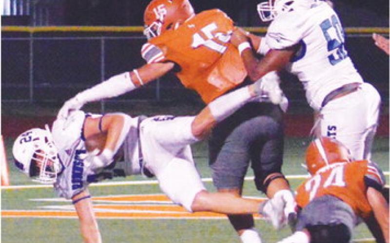 A ROBINSON PLAYER scores in the Rockets’ 28-0 road win over Caldwell. Defending for Caldwell are Josh Wilson and Adian Torres.