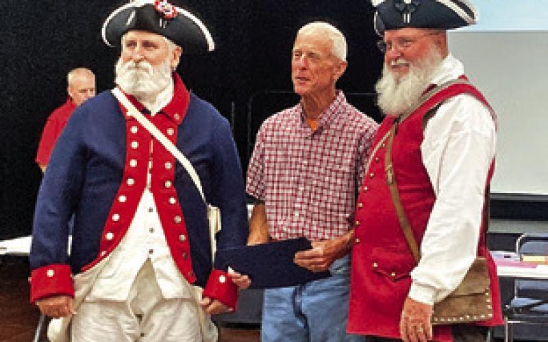 REPRESENTATIVES OF THE SONS of the American Revolution present Ben Ragnes with an award in recognition of his flag maintenance. Tribune photo by Sabine Lazo