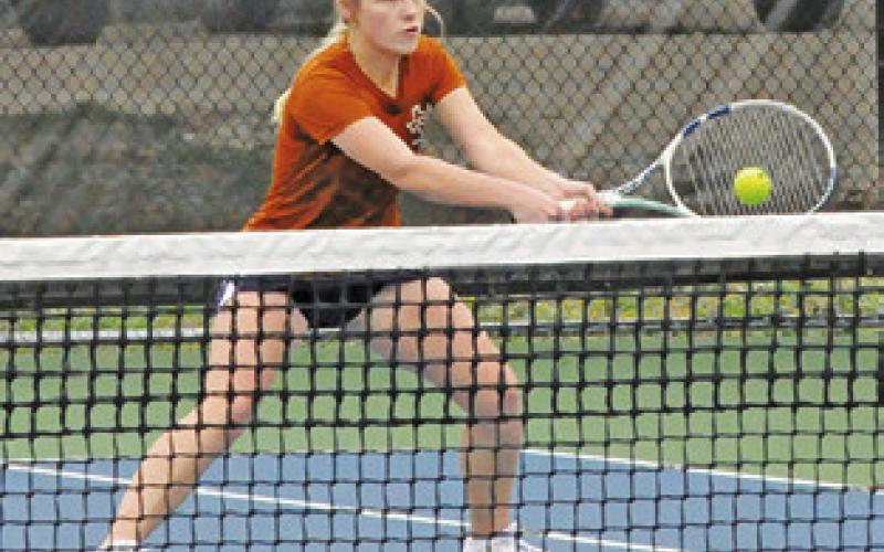 JORDAN PERKKIO volleys at the net during a mixed doubles match last Friday at the Caldwell Invitational Varsity Tournament.