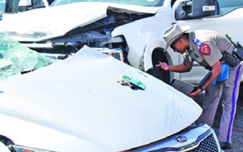 A DPS TROOPER works the scene of this acci- dent on Sunday on State Highway 36 South. Tribune photo by Roy Sanders