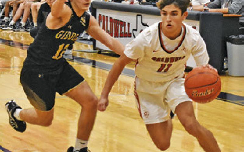 SPENCER ELLIS of Caldwell dribbles the ball around this Giddings defender. Tribune photo by Roy Sanders