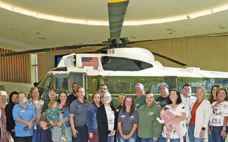 MEMBERS OF BURLESON COUNTY NONPROFIT organizations which participated in the annual Brazos Valley Gives posed in front of this helicopter at the Marine One/4141 Locomotive Pavilion at the George Bush Library on the campus of Texas A&amp;amp;M University during Brazos Valley Gives’ award event last Wednesday. See story inside. Tribune photo by Denise Squier