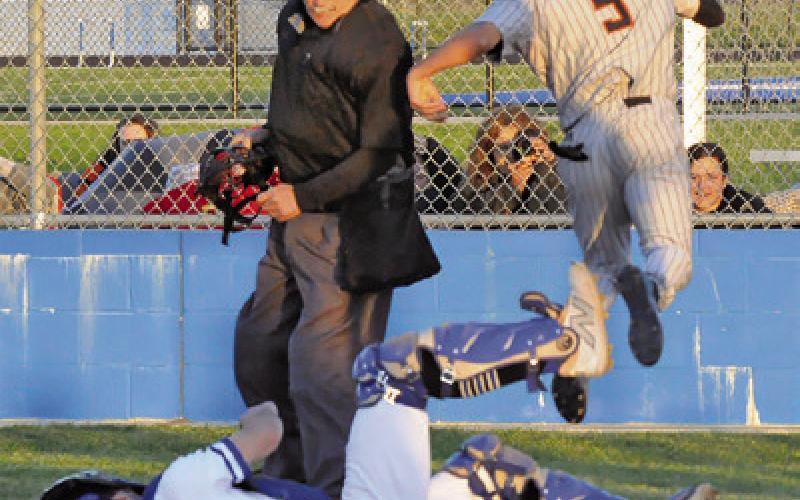SOMERVILLE’SKYLEBROOKS leaps high at home plate to get around Snook catcher Jordan Price. -- Tribune photo by Denise Squier