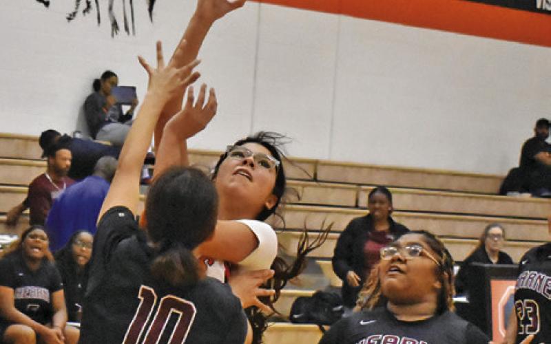 SOMERVILLE’S ARABELLA OROZCO takes a shot over Hearne’s Fernanda Luna while Hearne’s Katelyn Martinez watches. Tribune photo by Roy Sanders