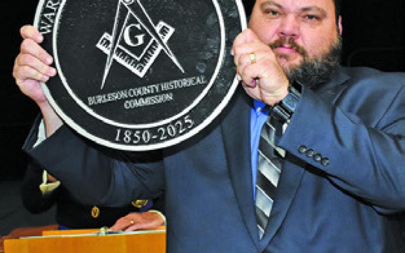 MICHAEL BENNETT displays this medallion presented to the Warren Masonic Lodge by the Burleson County Historical Commission.