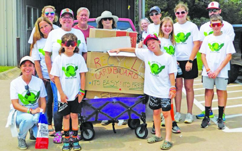 A CLEANUP CREW gathers after a busy day of work on Saturday. Local residents volunteered for the week-long cleanup effort.