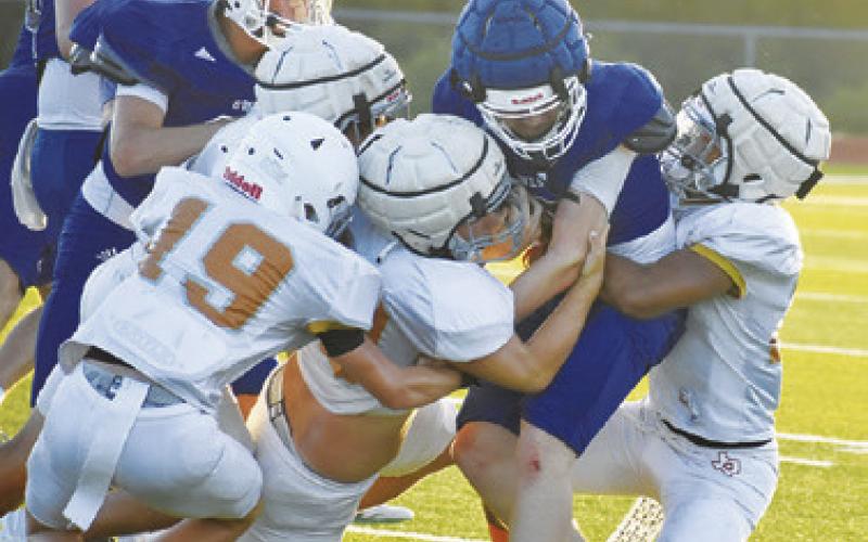 THE CALDWELL DEFENSE gang tackles this Anderson-Shiro ball carrier in the Aug. 13 scrimmage in Caldwell. Tribune photo by Roy Sanders