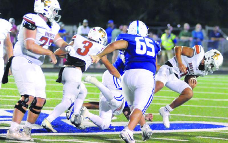 QUARTERBACK JOHN FRYREAR falls against Robinson. Also pictured are Coy Becka and Luke Freeman. Caldwell lost 55-14. Tribune photo by Denise Squier