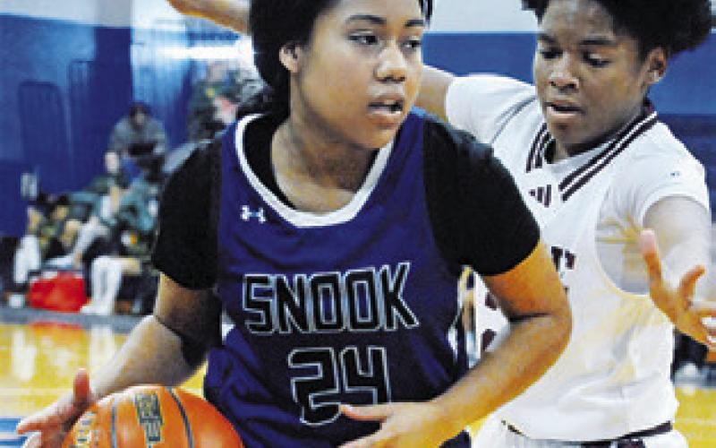 ALANA STRINGFELLOW dribbles past a Hearne player during the Snook-Hearne game at the Snook Lady Jay Basketball Tournament. -- Tribune photo by Denise Squier