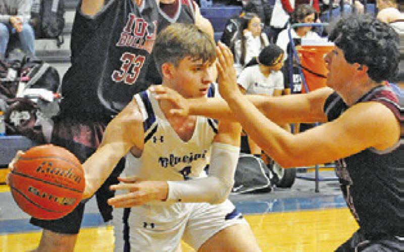 BRETT WITHEM tries to pass around this Iola defender in last Friday’s game in Snook. -- Tribune photo by Denise Squier