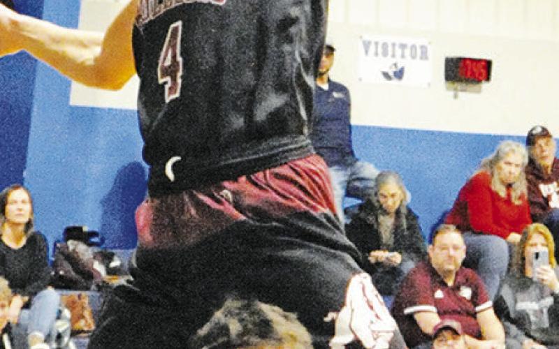 JOSH GREEN of Snook prepares to shoot last Friday in Snook as this Iola player lunges. Tribune photo by Denise Squier
