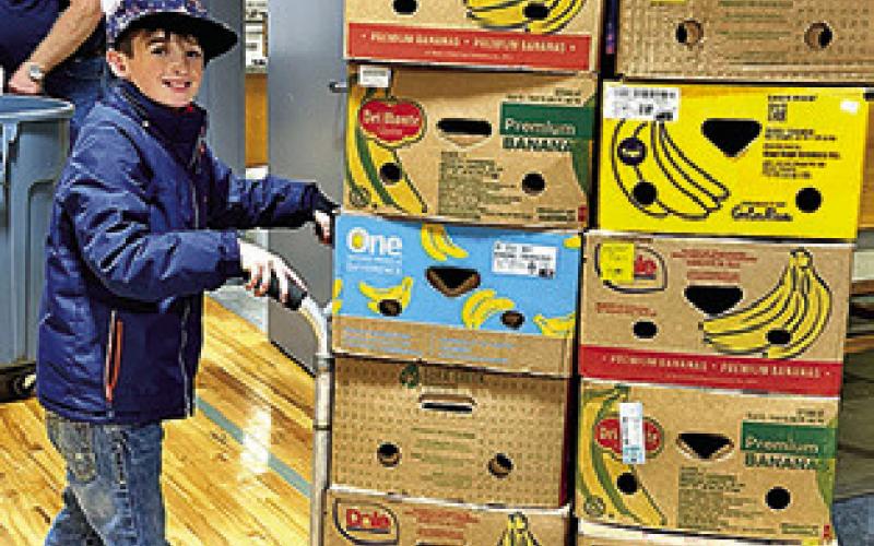 A YOUNG VOLUNTEER at last year’s Food for Families Food Drive, which collected over 12,000 pounds of food and over $64,000. Photo courtesy of Janice Easter
