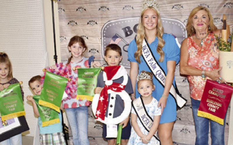 KYREN PLACHY WON a grand champion for a valentine wreath and pinecone succulents, Kolter Plachy for dill pickles, Kamden Plachy for a snowman wreath, ane Lillie Anderson won for a water color of a giraffe. Also pictured is Carolyn Doonan with her project, Fair Queen Hadleigh Novosad and Little Miss Avery Grace Freeman.