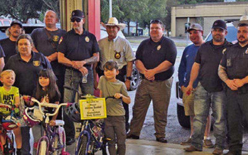 FOUR CHILDREN WERE BICYCLE winners at Caldwell’s National Night Out. The donors of the bicycles were Walmart, Mayor Janice Easter and the City of Caldwell. Pictured are the winners, Aubrey Deleon, Koleson Tonn, Charly Rodriguez and Jake Degraf and local first responders. Photo courtesy of Kyndall Tonn