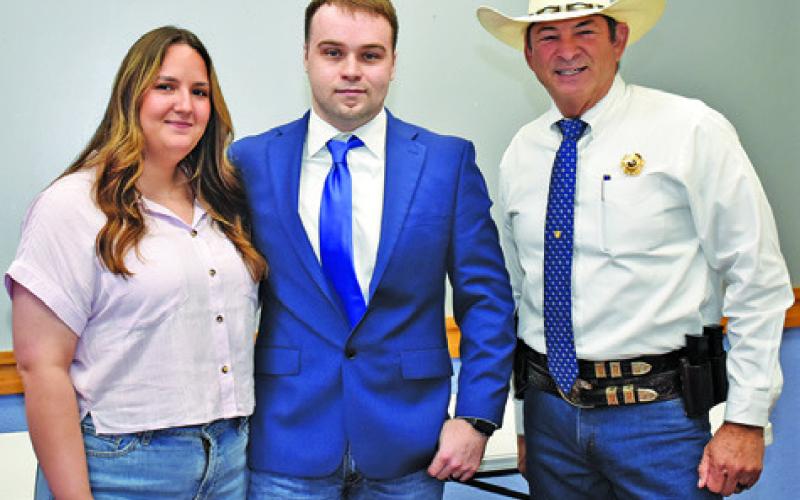 TEEX ACADEMY CADET Dylan Bryant is joined by Sheriff Bill Rios on Monday at the swearing in ceremony at the Caldwell Civic Center.