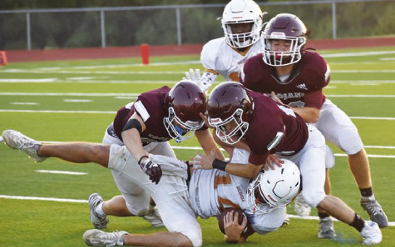 TROY DEFENDERS TACKLE Caden Schluens of Caldwell in the final scrimmage. -- Tribune photo by Roy Sanders