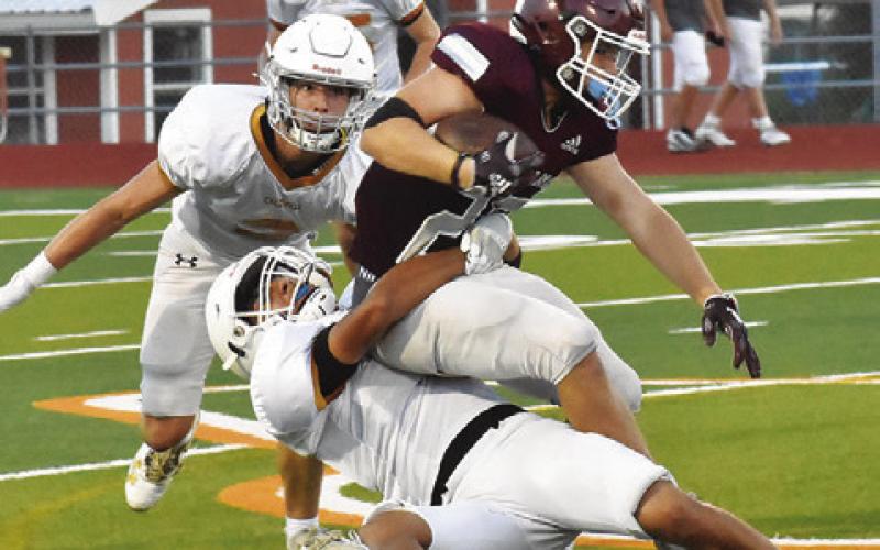 E.J. ROGERS OF Caldwell makes a tackle as Hays Beavers moves in to assist in the Troy scrimmage. -- Tribune photo by Roy Sanders