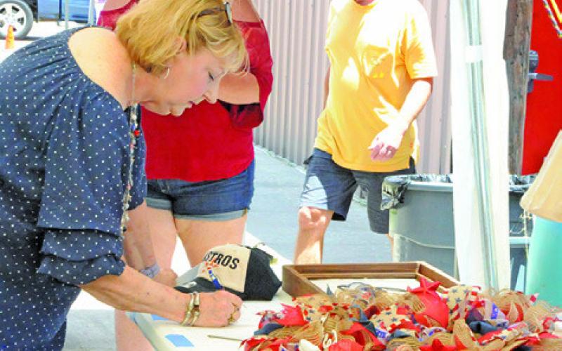 MANY PEOPLE BID ON ITEMS during the silent auction at Saturday’s fundraiser for the Birch Creek Volunteer Fire Department. Tribune photo courtesy of Denise Squier