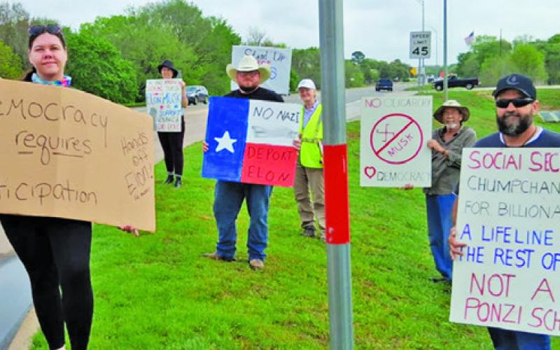 DEMONSTRATORS CALLING THEMSELVES “Patriots Against Elon Musk” line State Highway 21 at the new Tesla charging station in Caldwell as one of the over 200 “Tesla Takedown” protests across the nation on Saturday. Photo courtesy of Kassandra Langley
