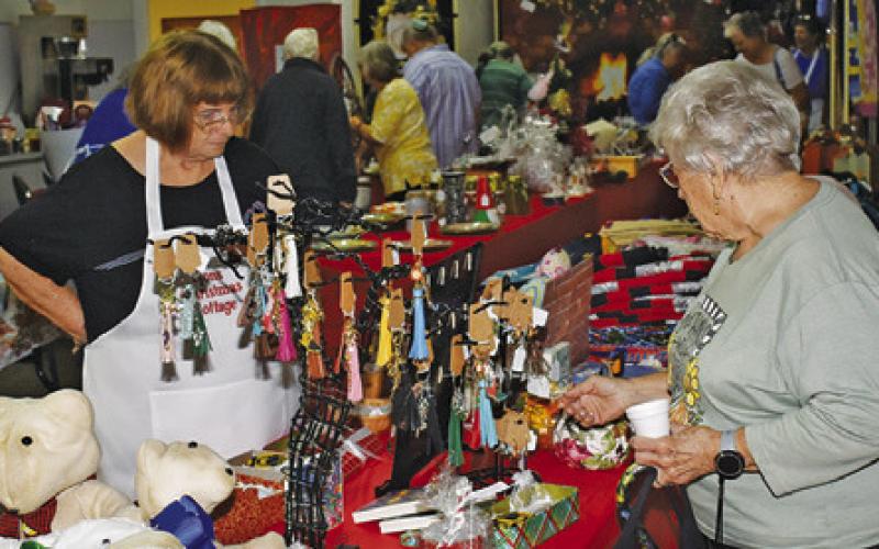 Shoppers examine the festive wares at this year’s Lyons Christmas Cottage arts, crafts, and bake sale. Tribune photo by Roy Sanders