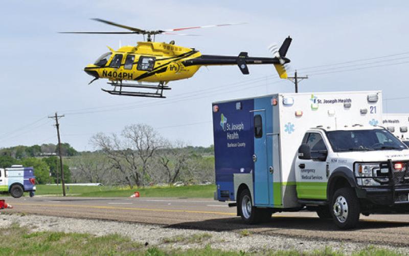 A HELICOPTER LANDS at the scene of the accident on State Highway 21 West.