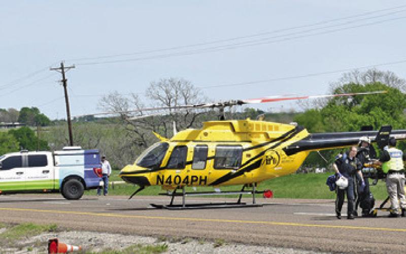 MEDICS GET THE stretcher out of the helicopter and head to the accident scene on State Highway 21. -- Tribune photo by Roy Sanders