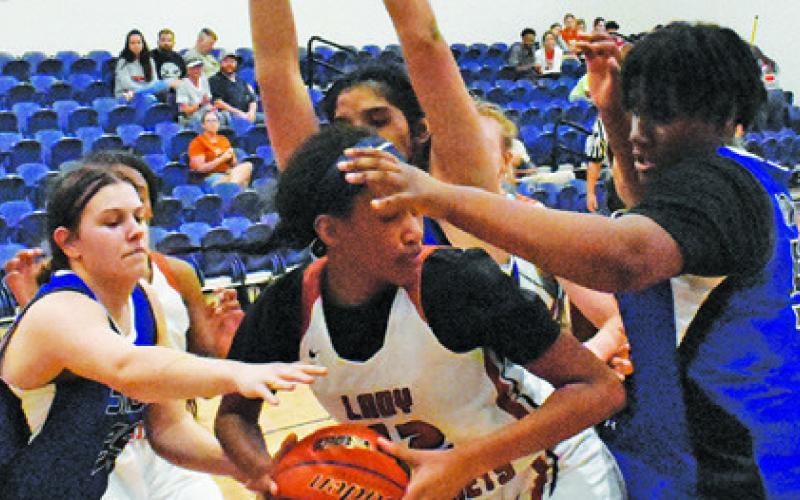 CALDWELL’S TYNIAH JOHNSON LOOKS to pass while a flock of Lady Jays defend.