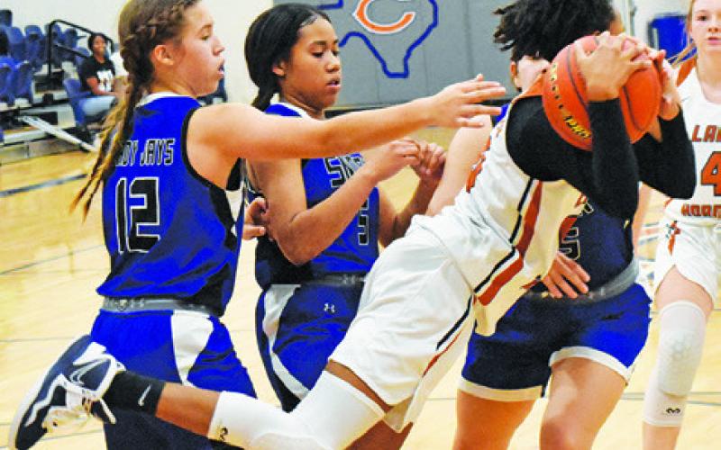 CALDWELL’S JAE MATHIS GETS POSSESSION of the ball while Snook’s Jadeyn Lara and Alana Stringfellow attempt to strip the ball. -- Tribune photo by Roy Sanders