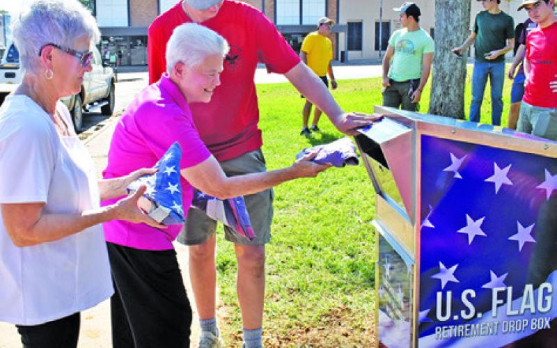 BEVERLY BROADDUS IS the first to drop off a flag at the flag retirement drop box on Sunday. Joining her is Becky Strauss and Alex York. Also pictured, in back, are Russell Ramirez, John Alford, Paul Johnson and Jackson Berndt. See story inside. Tribune photo by Roy Sanders