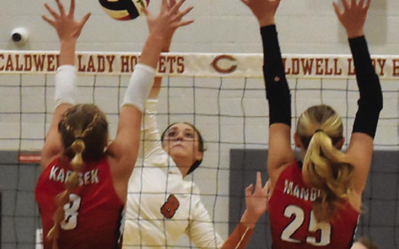 CALDWELL’S TATUM SUPAK battles at the net with two BVCHEA Homeschool blockers during Caldwell’s win Friday night. Tribune photo by Roy Sanders