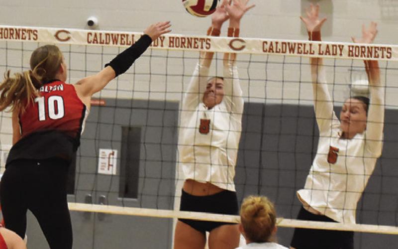 CALDWELL’S TATUM SUPAK and Kaely Brown storm the net to block a hit from a BVCHEA player Friday night. Tribune photo by Roy Sanders