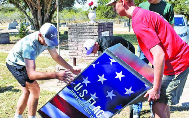 ALEX YORK, RIGHT, is assisted by, from left, Josh Eisle, Peter Najvar and Paul Johnson at the flag disposal box site at Oaklawn Cemetery. Tribune photo by Roy Sanders