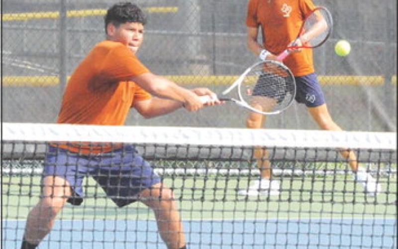CALDWELL’S KEVIN MARTINEZ volleys at the net while his boys doubles teammate Dylan Chapman looks on. The Hornet tennis team hosted Cameron Yoe last Thursday. -- Tribune photo by Denise Squier