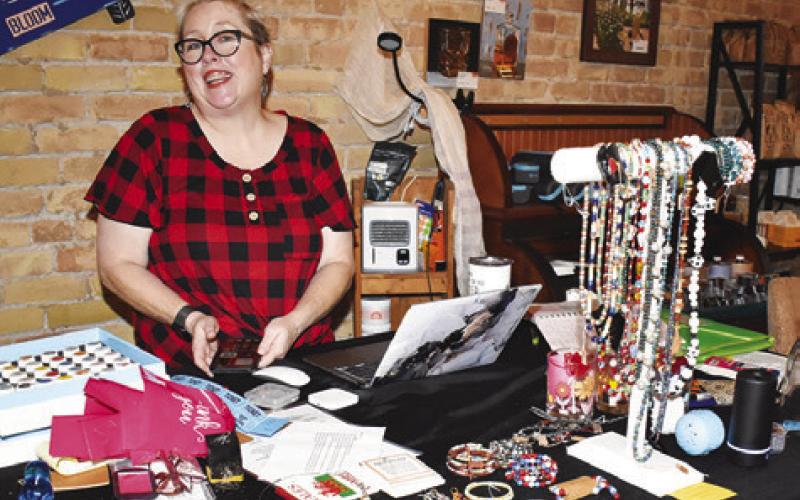 MOLLIE MARESH DISPLAYS her merchandise on Saturday, July 13, during the Main Street concert and street dance. Local businesses stayed open during the event. -- Tribune photo by Roy Sanders